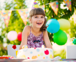 Pretty girl with cake at birthday party