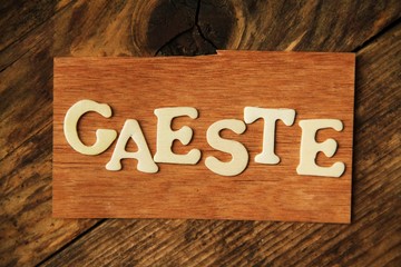 das Wort GAESTE auf Holztafel
