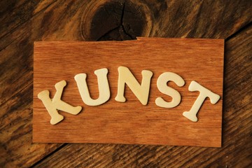 das Wort KUNST auf Holztafel
