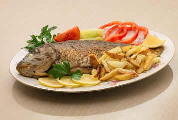 Fried carp with potato and vegetables