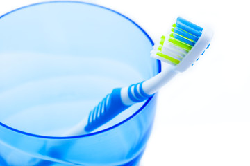 toothbrush in blue plastic glass
