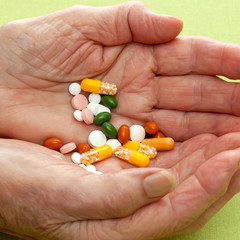 Senior woman holding assorted tablets.