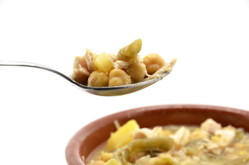 spoonful of stewed chickpeas with meat, beans and potatoes