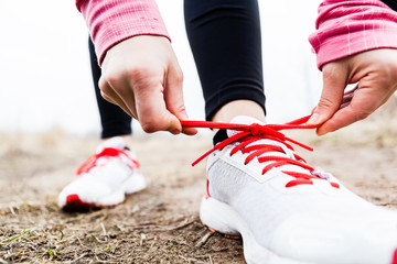 Woman runner tying sport shoes