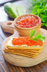 toasts with red caviar on board