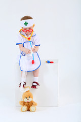 Little girl dressed as nurse bandages head to toy rabbit