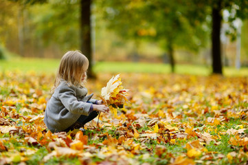 Adorable girl having fun on autumn day