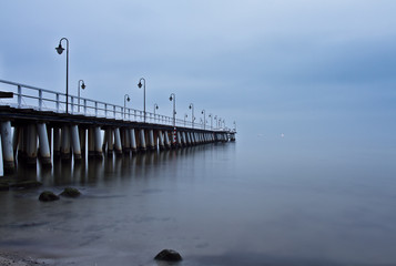 Fototapeta na wymiar Sunrise on the pier at the seaside, Gdynia Orlowo, Poland. Long 