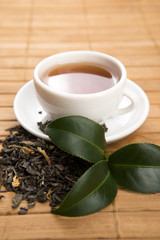 A cup of green tea with freh leaves