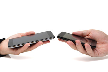 Two hands holding mobile smartphones while transferring data fro
