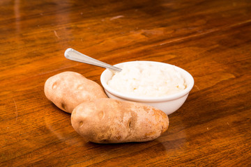 Bowl of Mashed Potatoes with Two Raw Ones