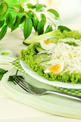 Delicious salad with eggs, cabbage and cucumbers on wooden