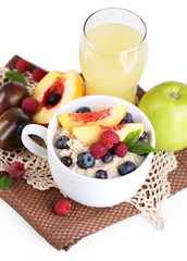 Oatmeal in cup with berries on napkins isolated on white