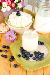Fresh dairy products with blueberry on wooden table close-up