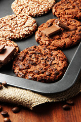 Homemade cookies on dripping pan, on wooden background