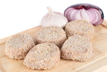 Meat patties on board isolated on white
