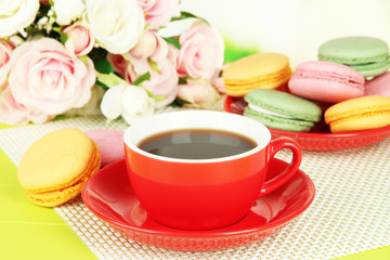 Coffee and macaroons on table on light background