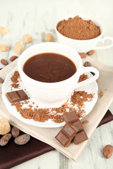Cocoa powder in cup on napkin on wooden table