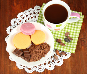 Cocoa in cup with sweets and cocoa powder
