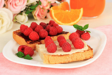 Delicious toast with raspberries on table close-up