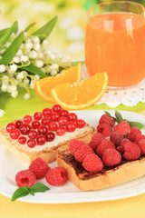 Delicious toast with berries on table on bright background