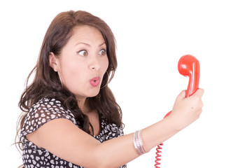 portrait of young woman talking on vintage telephone against a