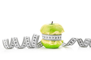 white measuring tape and apple
