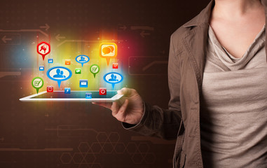 Girl presenting a tablet with colorful social icons and signs