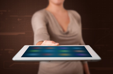 Woman holding a white tablet with blurry apps