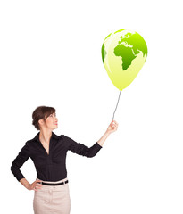 Happy lady holding a green globe balloon