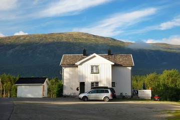 Detached house under green mountain.