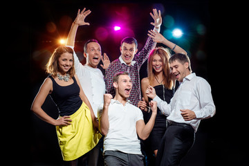 Cheerful group of young people dancing at party