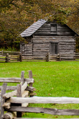 Beautiful Autumn scene showing rustic old log cabin surrounded b