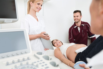 Fototapeta premium Doctor Showing Digital Tablet To Expectant Couple