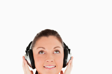 Fototapeta premium Portrait of a gorgeous woman posing with headphones while standi