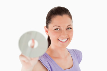 Beautiful woman holding a CD while standing