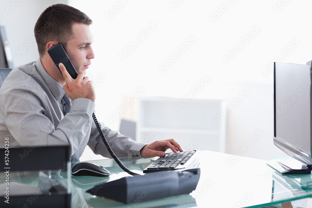 Wall mural businessman typing while on the phone