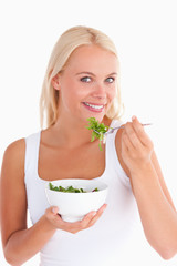 Smiling woman eating salad