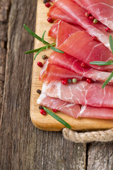 sliced prosciutto on a wooden board