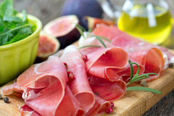 sliced prosciutto on a wooden board