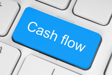 Blue cash flow button on white keyboard.