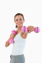 Fototapeta na wymiar Portrait of a happy woman working out with dumbbells