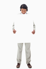 Businessman looking at blank sign he is holding