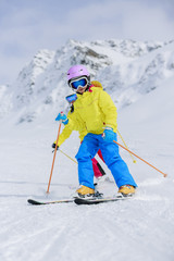 Skiing, skiers on ski run - child skiing downhill