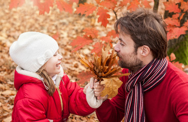 Smiling father and daughter having fun outdoor in autumn