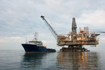 Oil rig being tugged in the sea