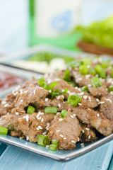 Bulgogi - Korean grilled beef with side dishes and lettuce