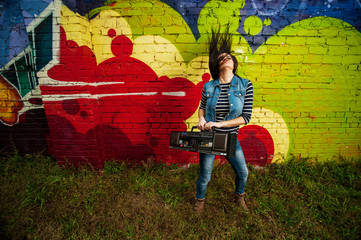 Girl dancing in front of graffiti with recorder