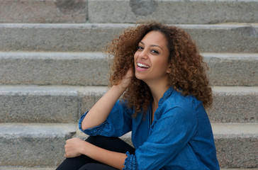 Portrait of a young woman laughing outdoors