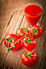 Tomato juice in glass and fresh organic tomatoes